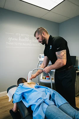 Dr. Alex Marquignon using softwave on a patient's back