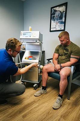Dr. Zachary Zdrada treating a patient's knee with softwave